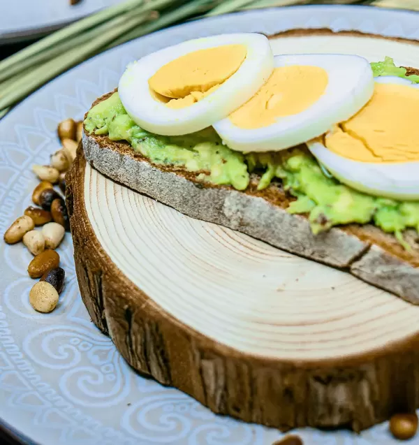 Roggenbrot mit Avocado, Pinienkernen und gekochtem Ei